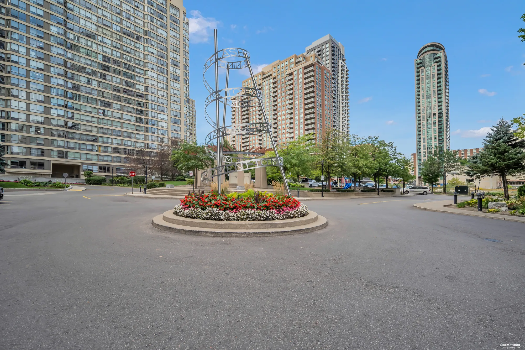 The courtyard drive with a round flower bed and a sculpture, the towers around it