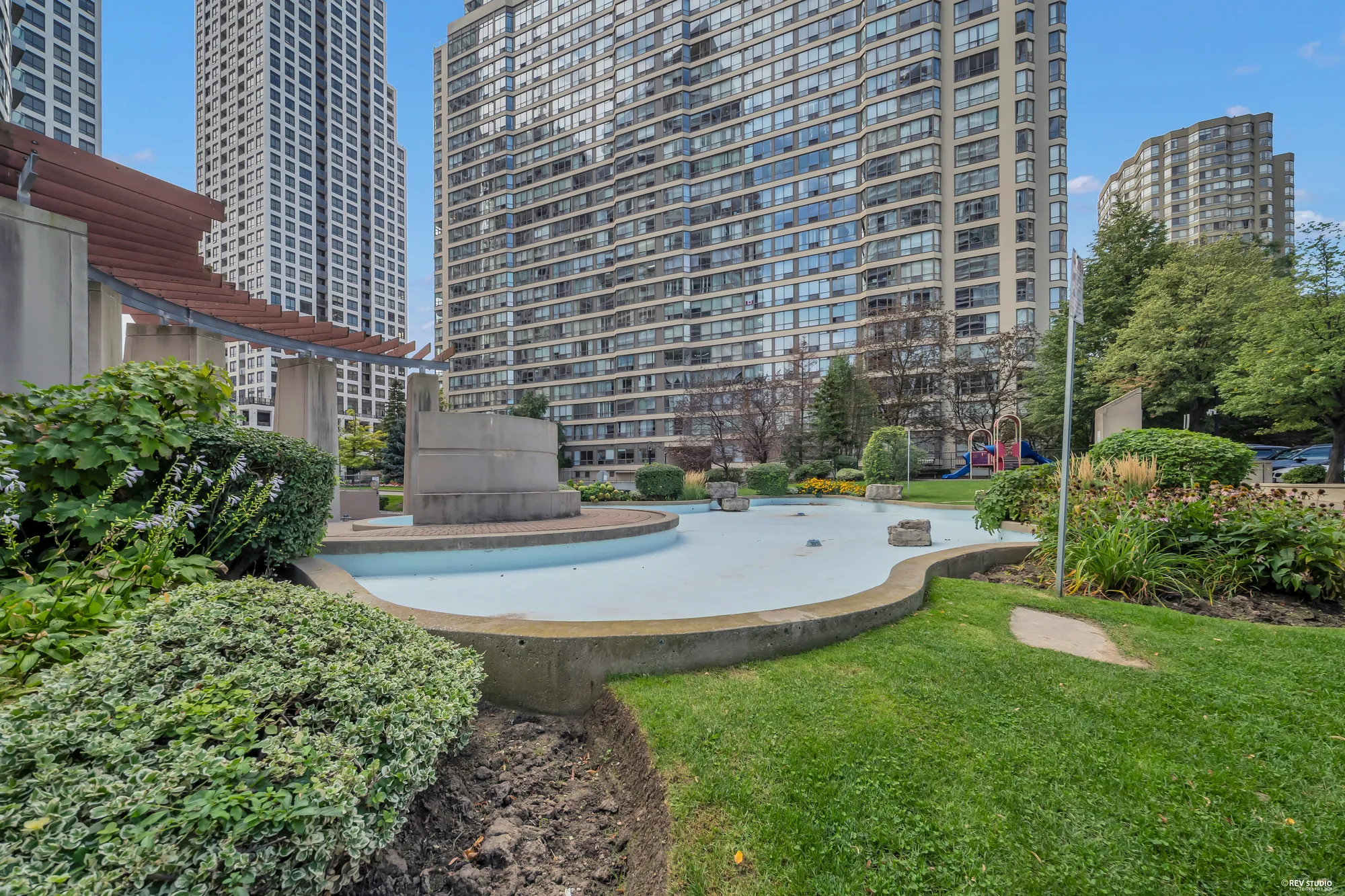 The fountain garden: a pool with a fountain, shrubs and lawn, the towers beyond