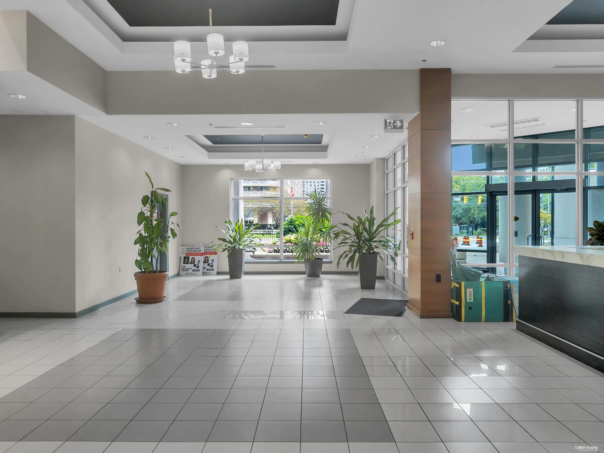 The lobby toward the concierge desk and the doors, plants either side