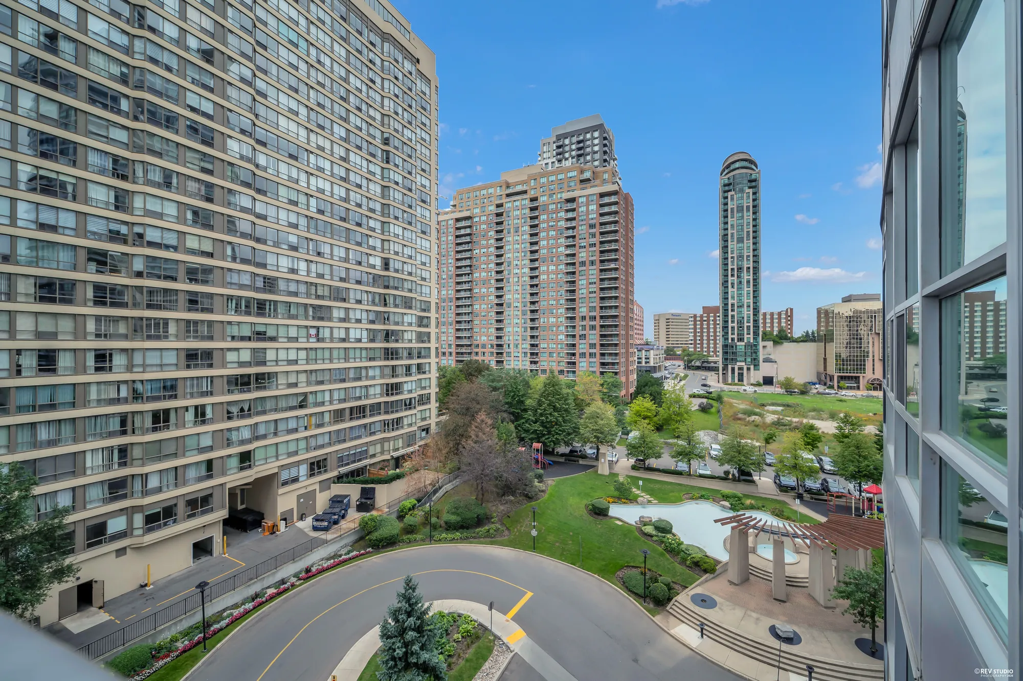 From the balcony: the neighbouring towers across the courtyard, the fountain garden and the drive below, trees and the city beyond