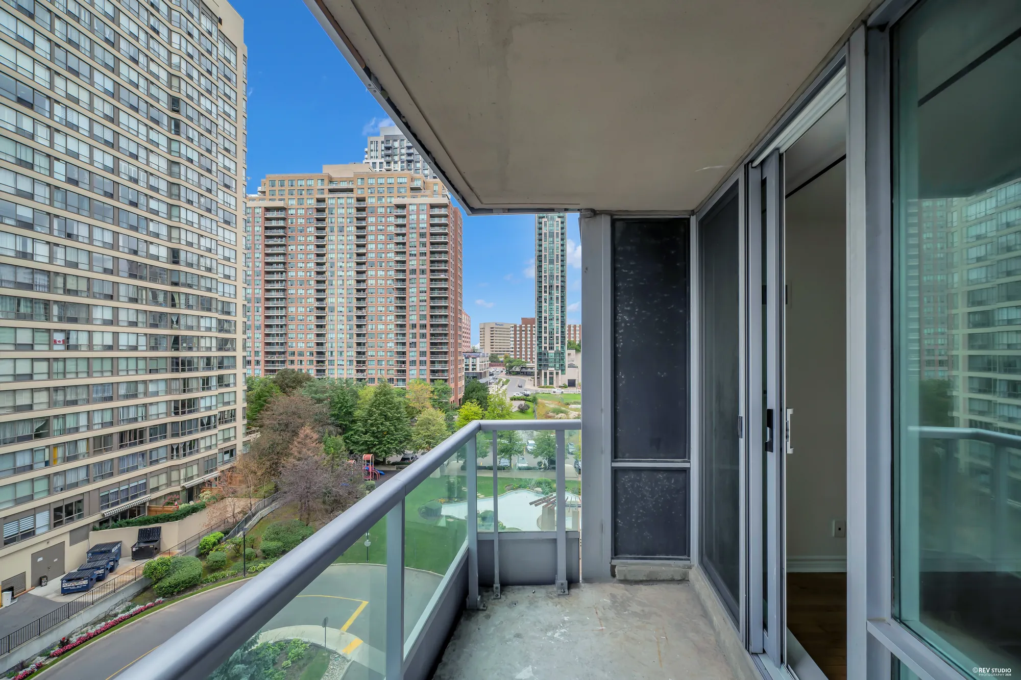 The balcony from its door: the railing, the towers, the trees below