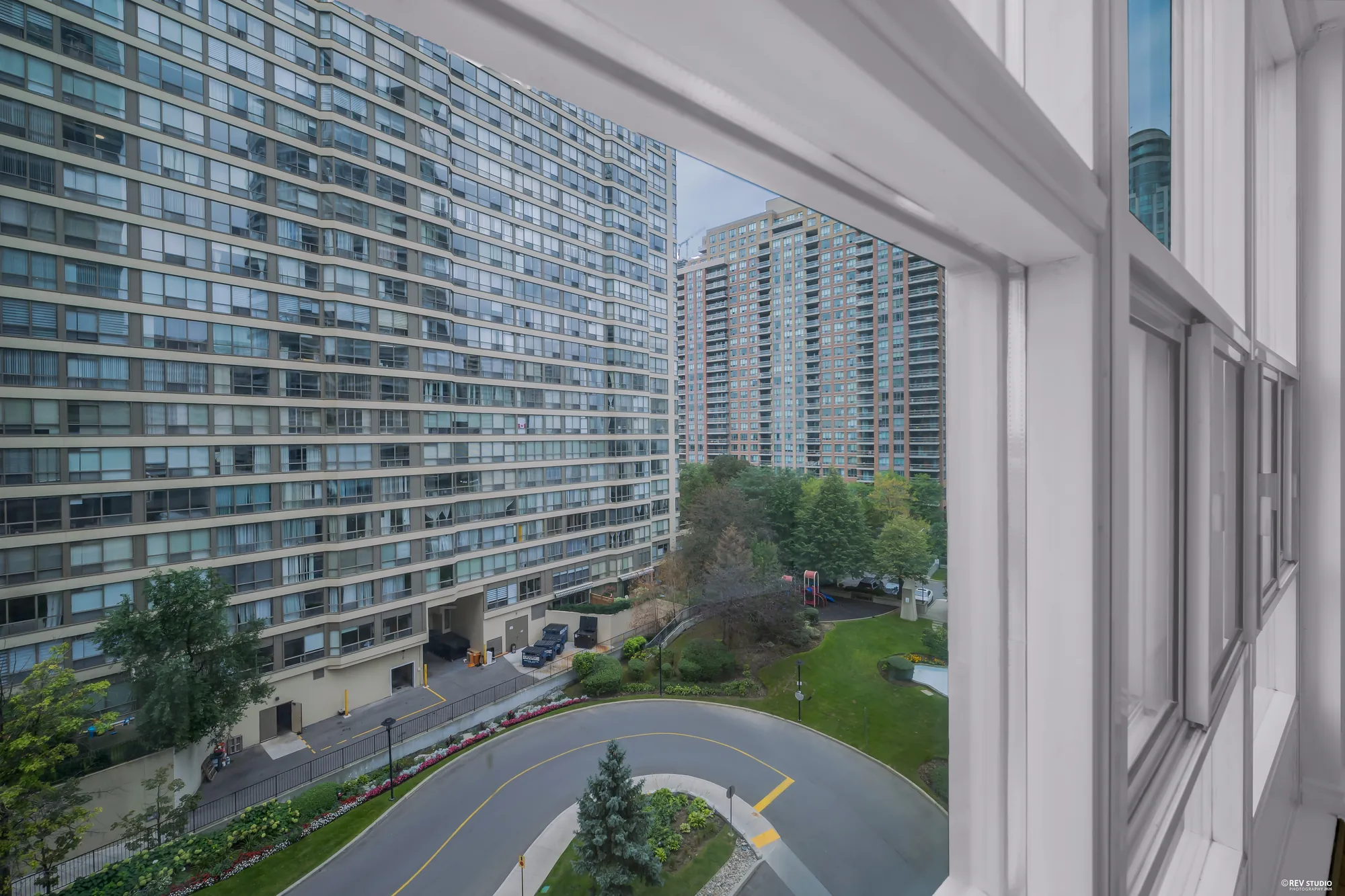 Straight down from the balcony: the courtyard drive and gardens between the towers